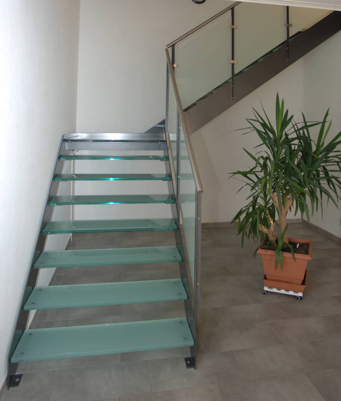 Metallwangentreppe mit Stufen und Podest aus Glas mit Mattfolie. Geländer mit T-Pfosten, Glasfüllung und CNS-Handlauf.