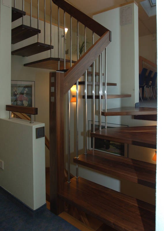 Escalier autoportant en noyer couleur naturelle, poteau de départ, balustres, entretoises et goujons sont carrés. 